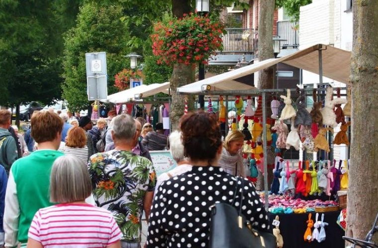 Drukte op de jaarmarkt in Hillegom met bezoekers tussen kleurige kramen in het winkelgebied